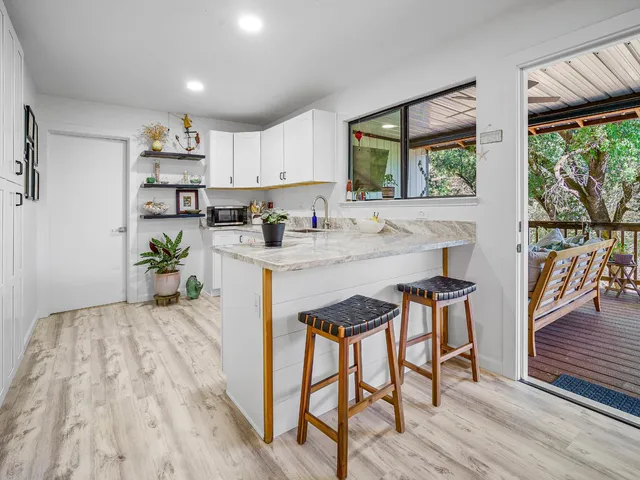 a kitchen with stainless steel appliances a white table chairs in it and white cabinets