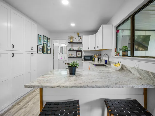 a kitchen with white cabinets and sink