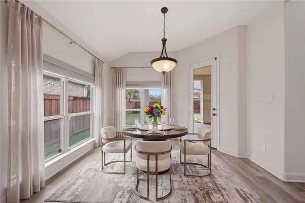 a dining room with furniture a chandelier and wooden floor