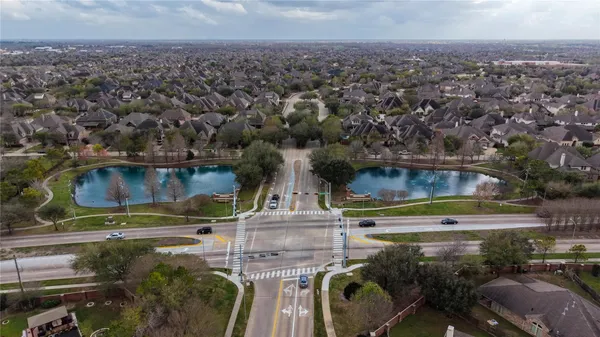 an aerial view of a residential houses with outdoor space and street view