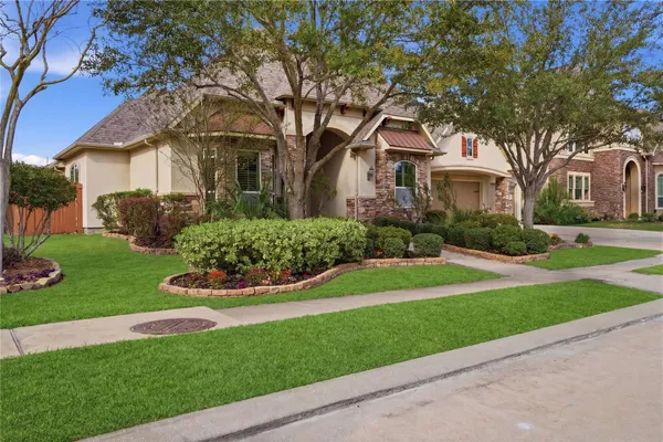 a front view of a house with a garden and tree