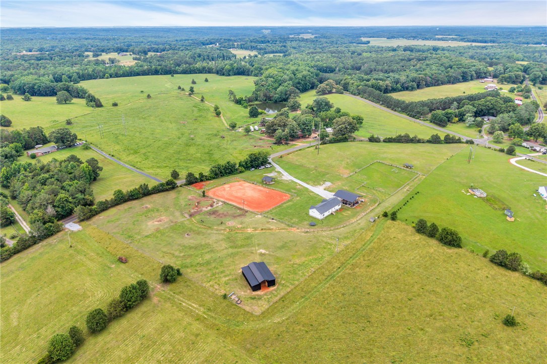 615 Wilson Road Central, SC 29630 - Photo 44 of 50 Fenced pastures and outbuildings span across this expansive rural acreage under open skies.