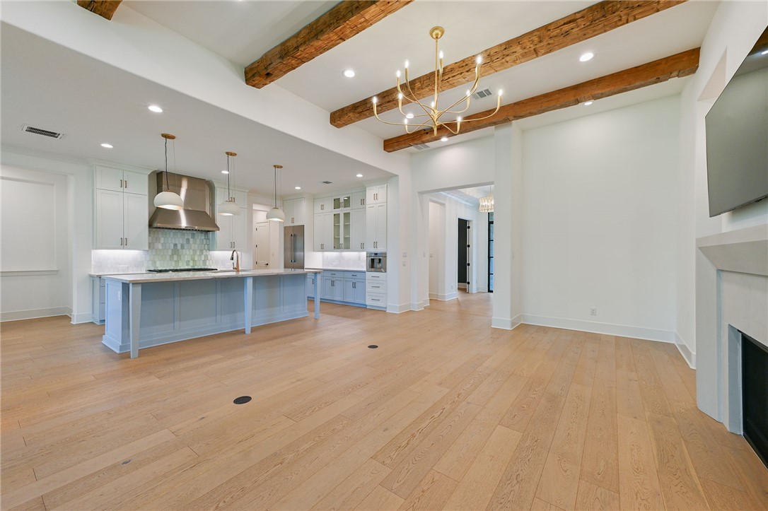 5115 Inverness Drive Bryan, TX 77802 - Photo 5 of 28 Kitchen featuring a large central island with a light blue finish, light wood-finish flooring, white upper cabinetry, light blue lower cabinetry, and stainless steel appliances
