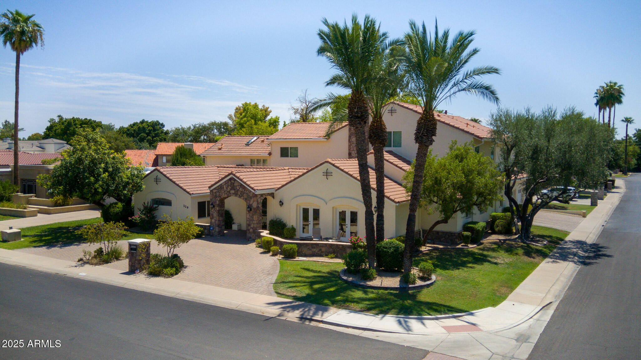a front view of a house with garden and trees