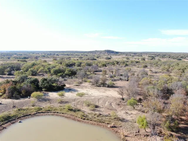 an aerial view of house with yard and mountain in the background