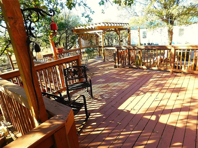 a view of a street with wooden fence and large trees