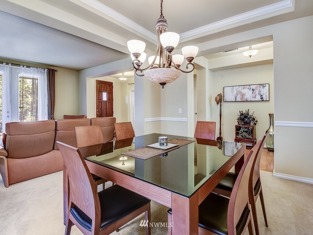 17070 Parkside Way Southeast Renton, WA 98058 - Photo 6 of 25 a view of a dining room with furniture and a chandelier