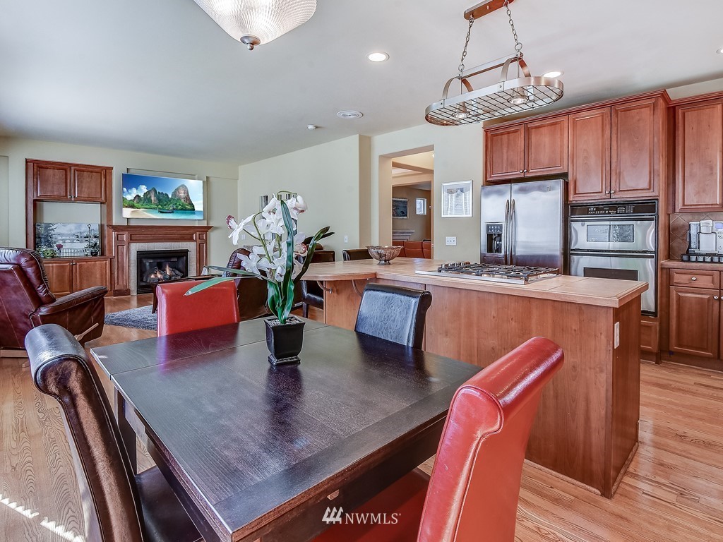 17070 Parkside Way Southeast Renton, WA 98058 - Photo 10 of 25 a view of a dining room with furniture a chandelier and wooden floor