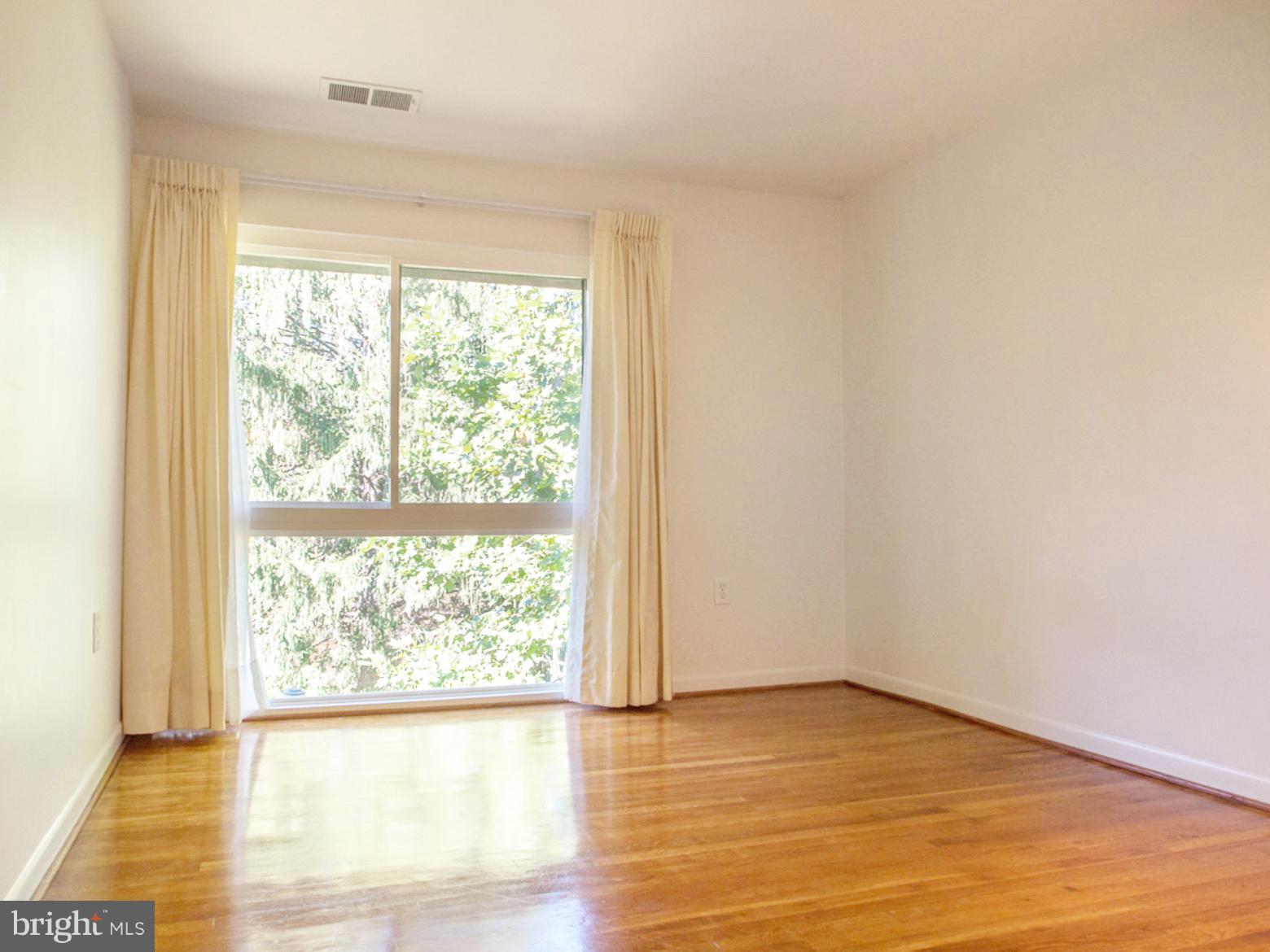 11168 Saffold Way Reston, VA 20190 - Photo 15 of 28 a view of an empty room with wooden floor and a window
