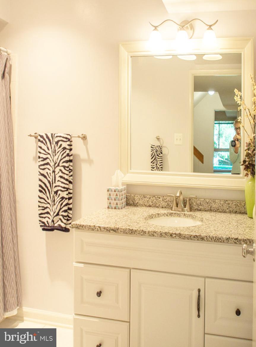 11168 Saffold Way Reston, VA 20190 - Photo 19 of 28 a bathroom with a granite countertop sink and a mirror