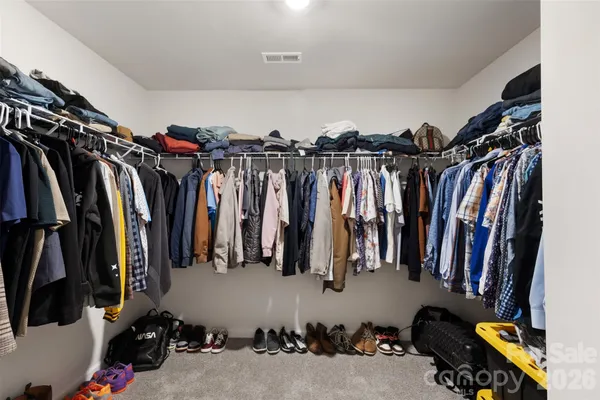 a view of walk in closet with clothes and shoes