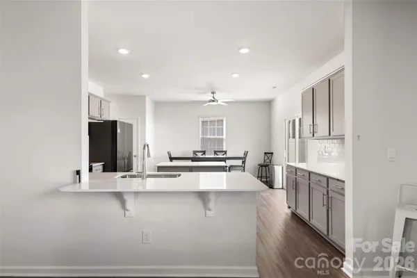 a view of a kitchen with kitchen island stainless steel appliances refrigerator sink and stove