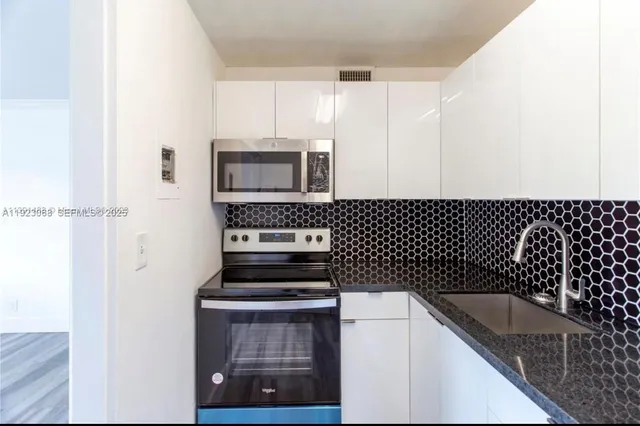 a kitchen with a sink a stove and cabinets