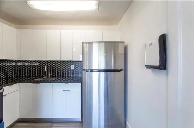a kitchen with a refrigerator and a sink