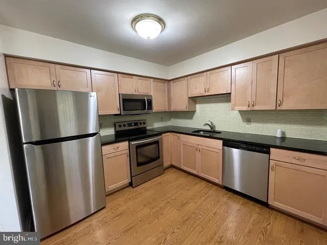 a kitchen with granite countertop a refrigerator stove and microwave