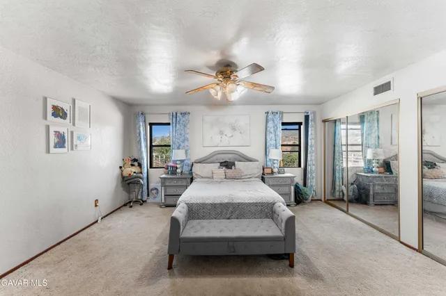 a spacious bedroom with a bed and a chandelier