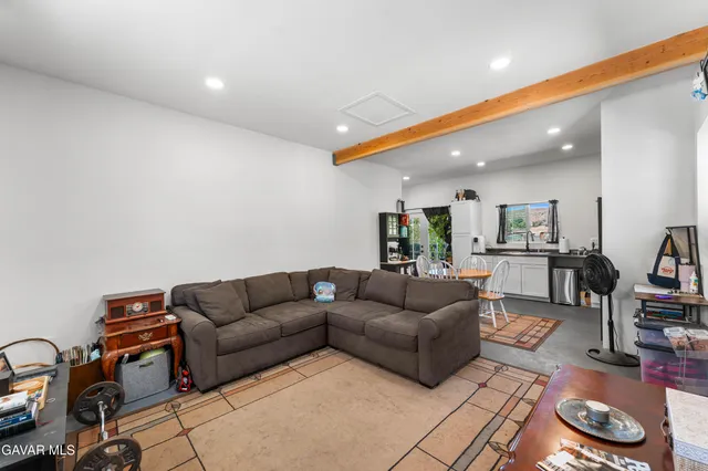 a living room with furniture a rug and kitchen view