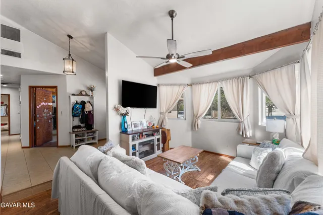 a living room with furniture a flat screen tv and a window