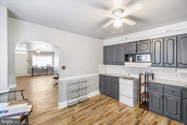 a kitchen with stainless steel appliances a stove a sink cabinets and wooden floor