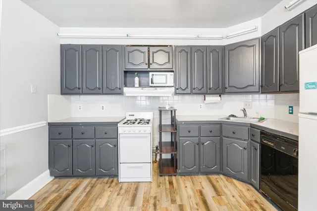 a kitchen with a sink stove and cabinets