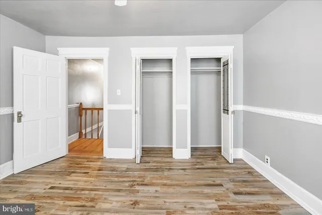 a view of a livingroom with wooden floor and staircase
