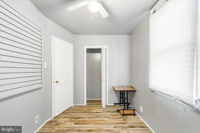 a view of a bedroom with a bed and wooden floor