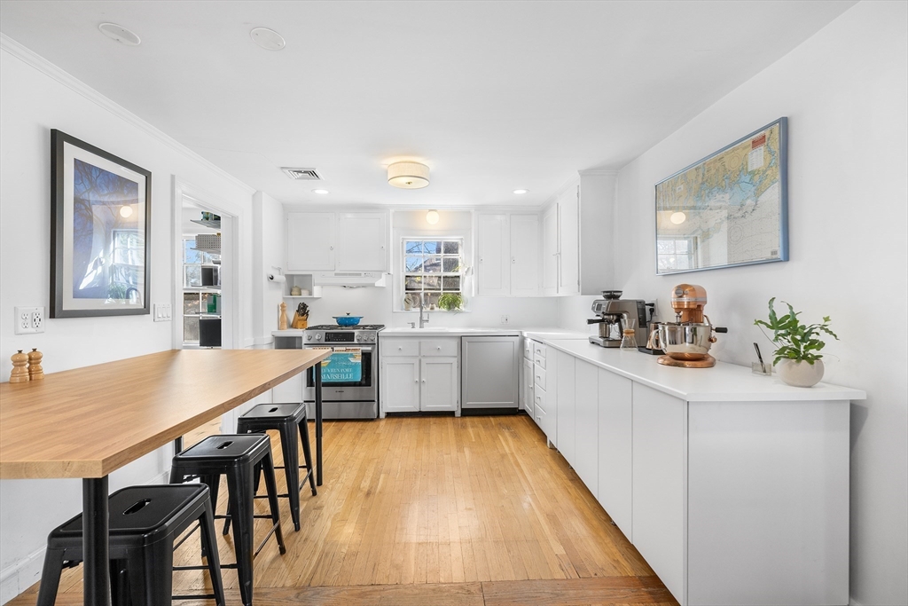 21 Ridge Avenue Newton, MA 02459 - Photo 8 of 27 a kitchen with stainless steel appliances a table and chairs in it