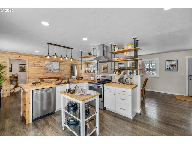 a open kitchen with stainless steel appliances kitchen island granite countertop a stove a sink and a refrigerator