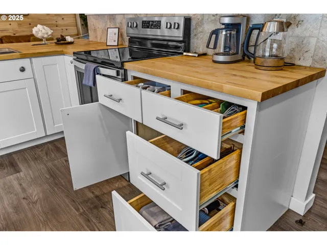 a kitchen with stainless steel appliances cabinets and wooden floor