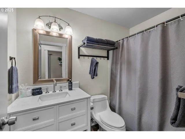 a bathroom with a granite countertop sink mirror vanity and toilet