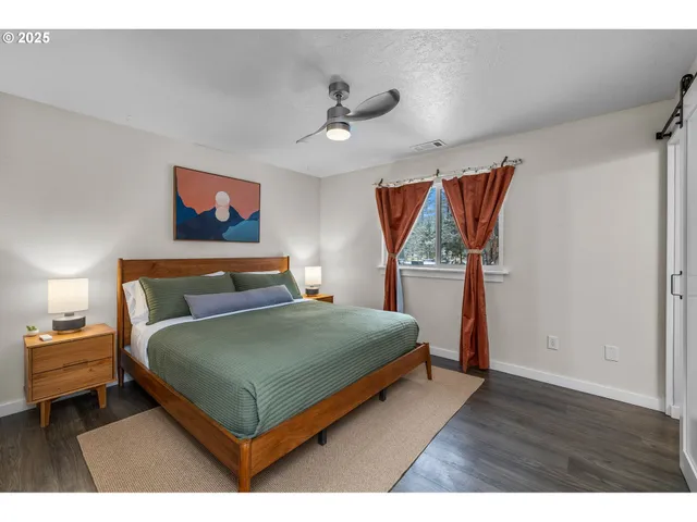 a bedroom with a bed and a painting on the wall