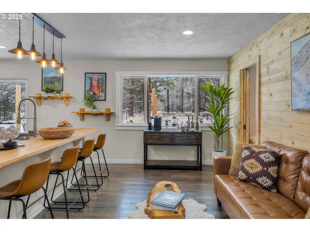 a living room with furniture a chandelier and a dining table