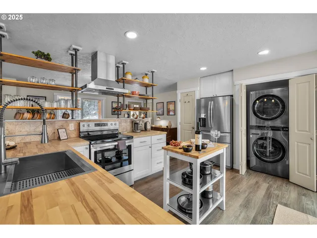 a living room with stainless steel appliances kitchen island granite countertop a stove and a refrigerator
