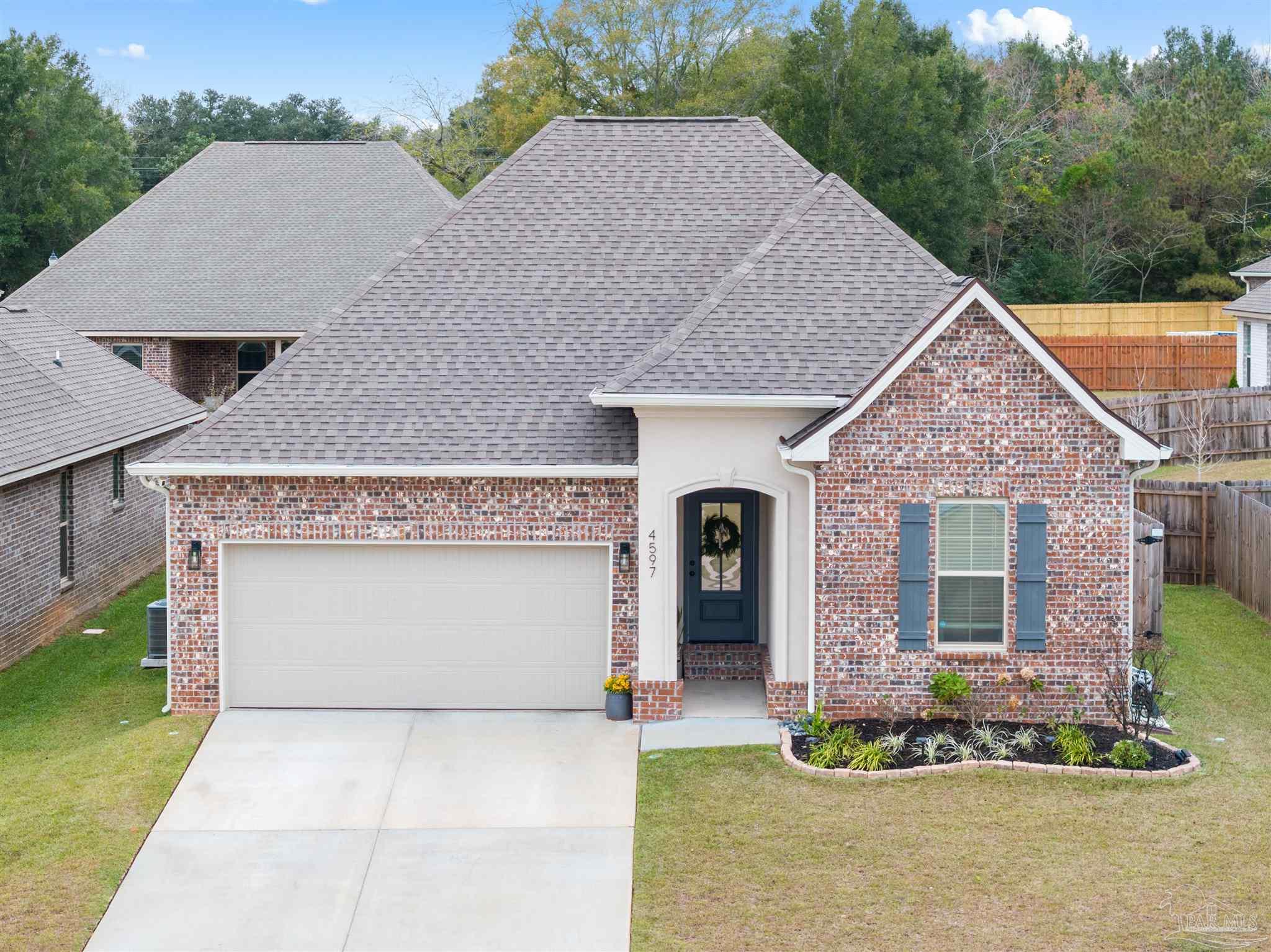 a front view of a house with a garden and plants