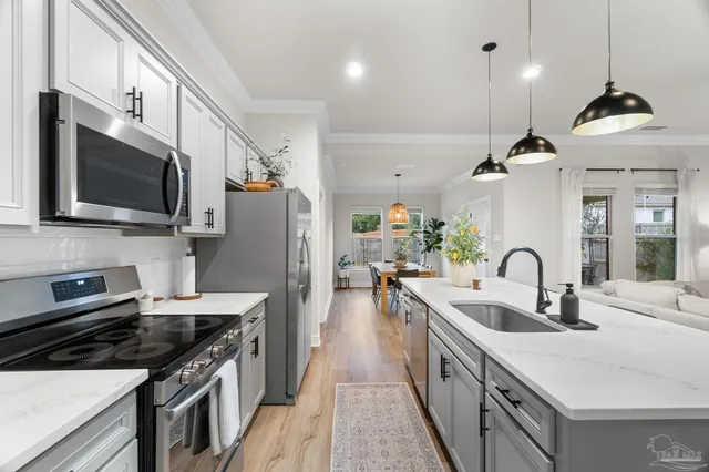 a kitchen with stainless steel appliances a sink stove and refrigerator