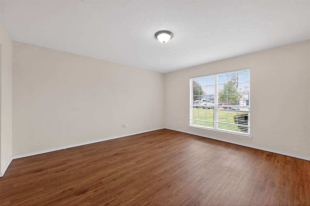 8618 Scooner Street Rowlett, TX 75089 - Photo 15 of 30 a view of an empty room with wooden floor and a window