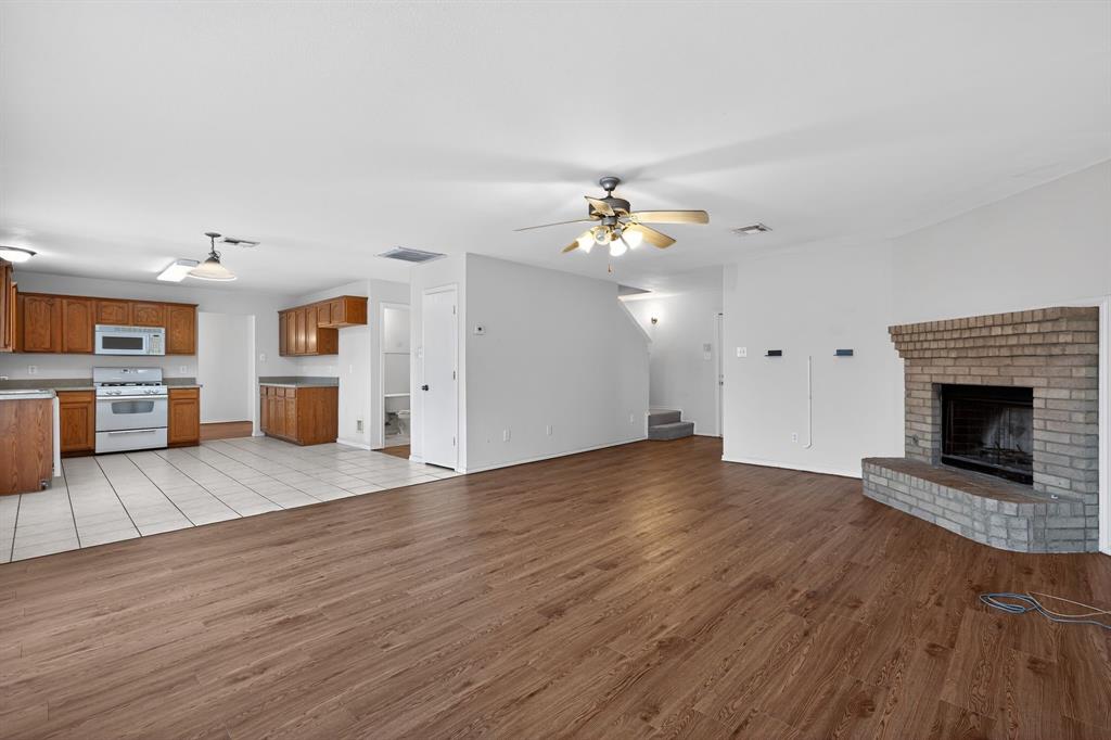 8618 Scooner Street Rowlett, TX 75089 - Photo 16 of 30 a view of a kitchen with a sink hardwood floor and a fireplace