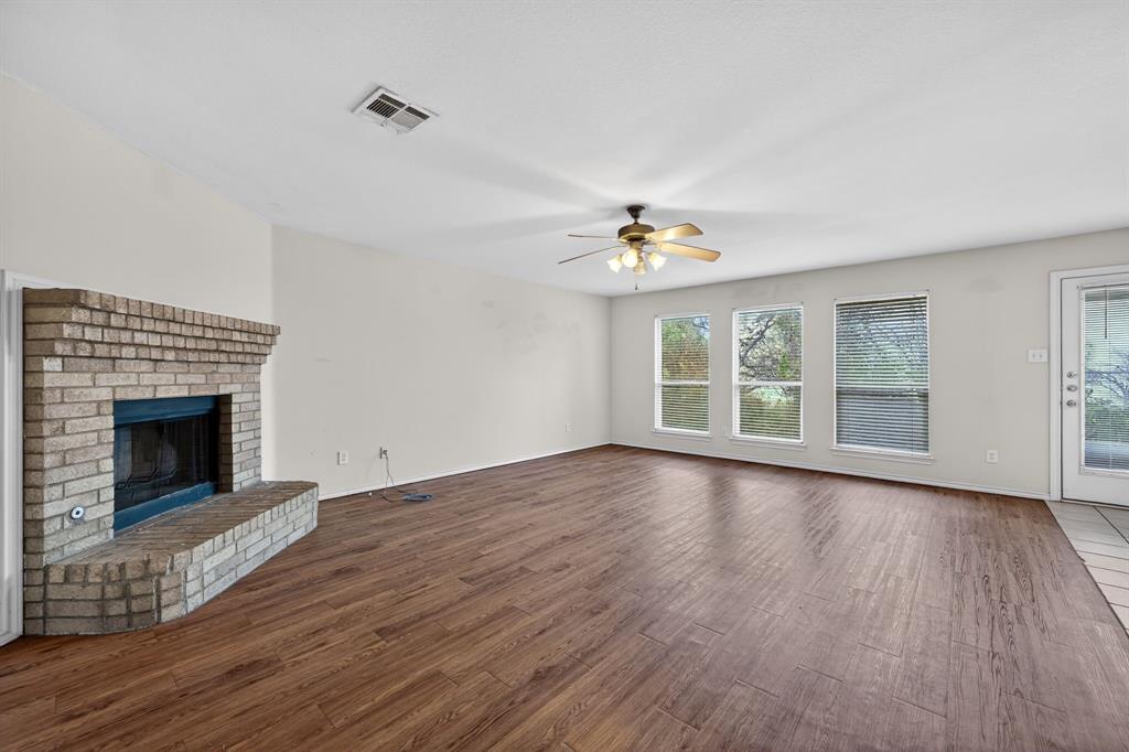 8618 Scooner Street Rowlett, TX 75089 - Photo 17 of 30 a view of an empty room with wooden floor fireplace and a window