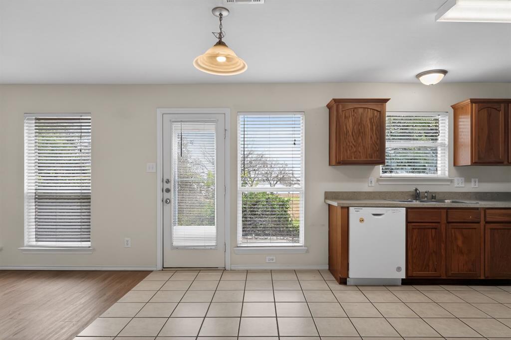 8618 Scooner Street Rowlett, TX 75089 - Photo 20 of 30 a view of a kitchen with a sink dishwasher and wooden cabinets