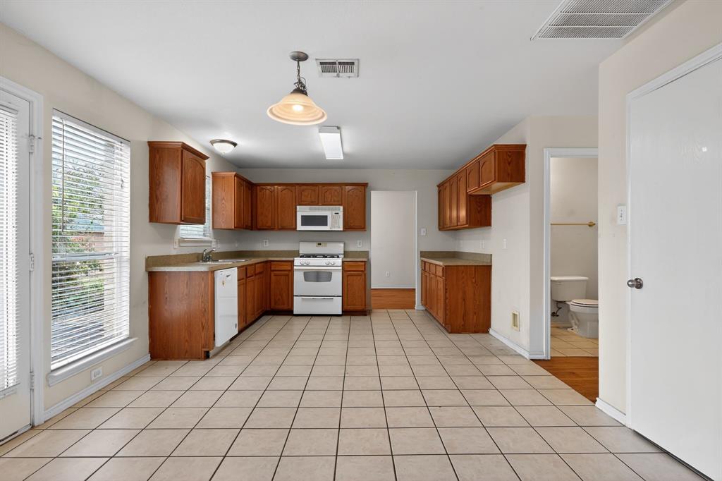 8618 Scooner Street Rowlett, TX 75089 - Photo 22 of 30 a kitchen with stainless steel appliances a sink cabinets and a window