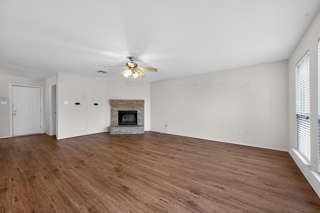 8618 Scooner Street Rowlett, TX 75089 - Photo 9 of 30 a view of an empty room with wooden floor and fireplace