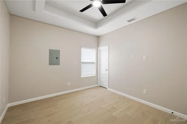 an empty room with a ceiling fan and windows