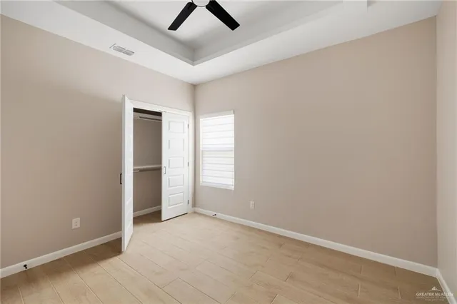 an empty room with closet and windows