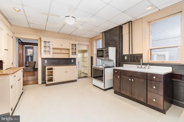 an empty room with windows and fireplace