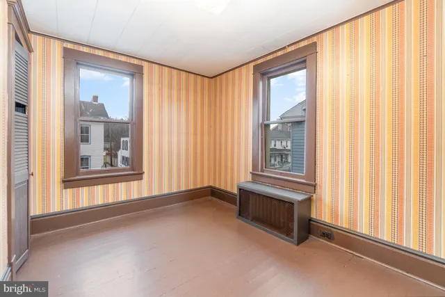 a view of an empty room with wooden floor