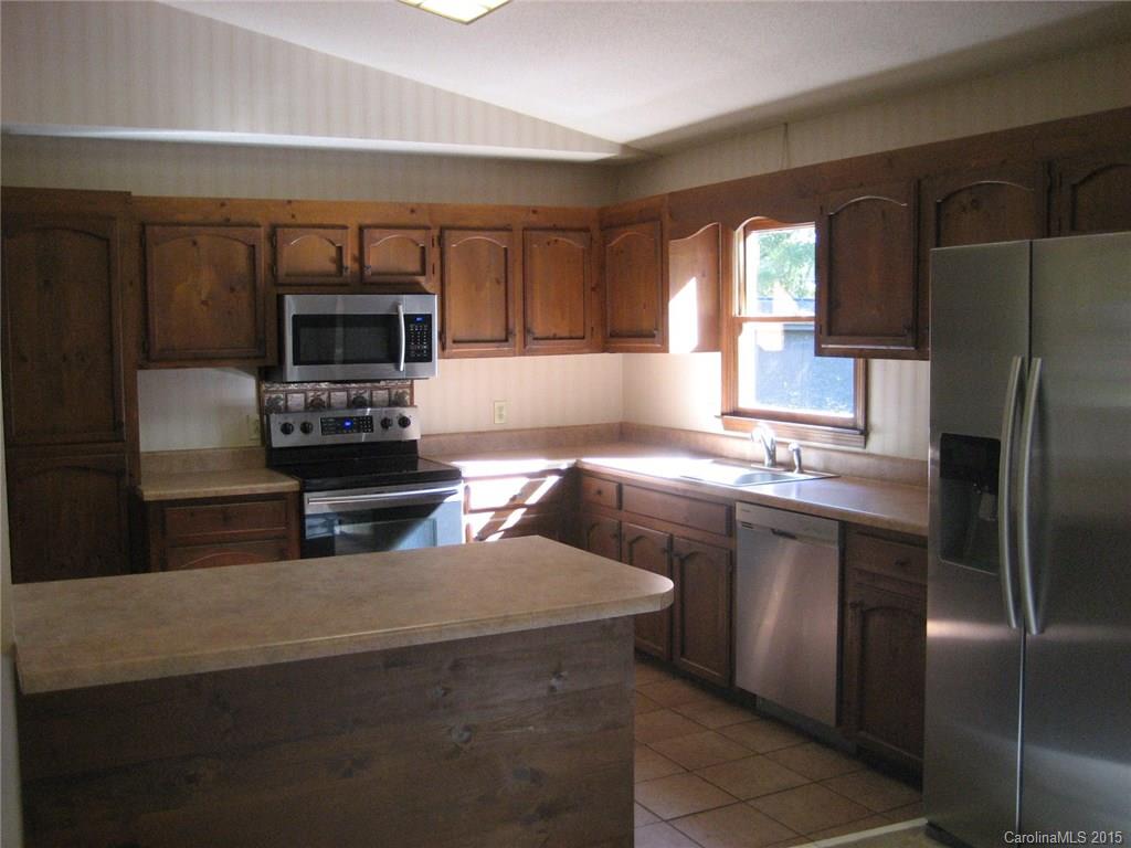755 Shady Forest Road, Unit 2 Clover, SC 29710 - Photo 5 of 24 a kitchen with kitchen island granite countertop a stove refrigerator and microwave