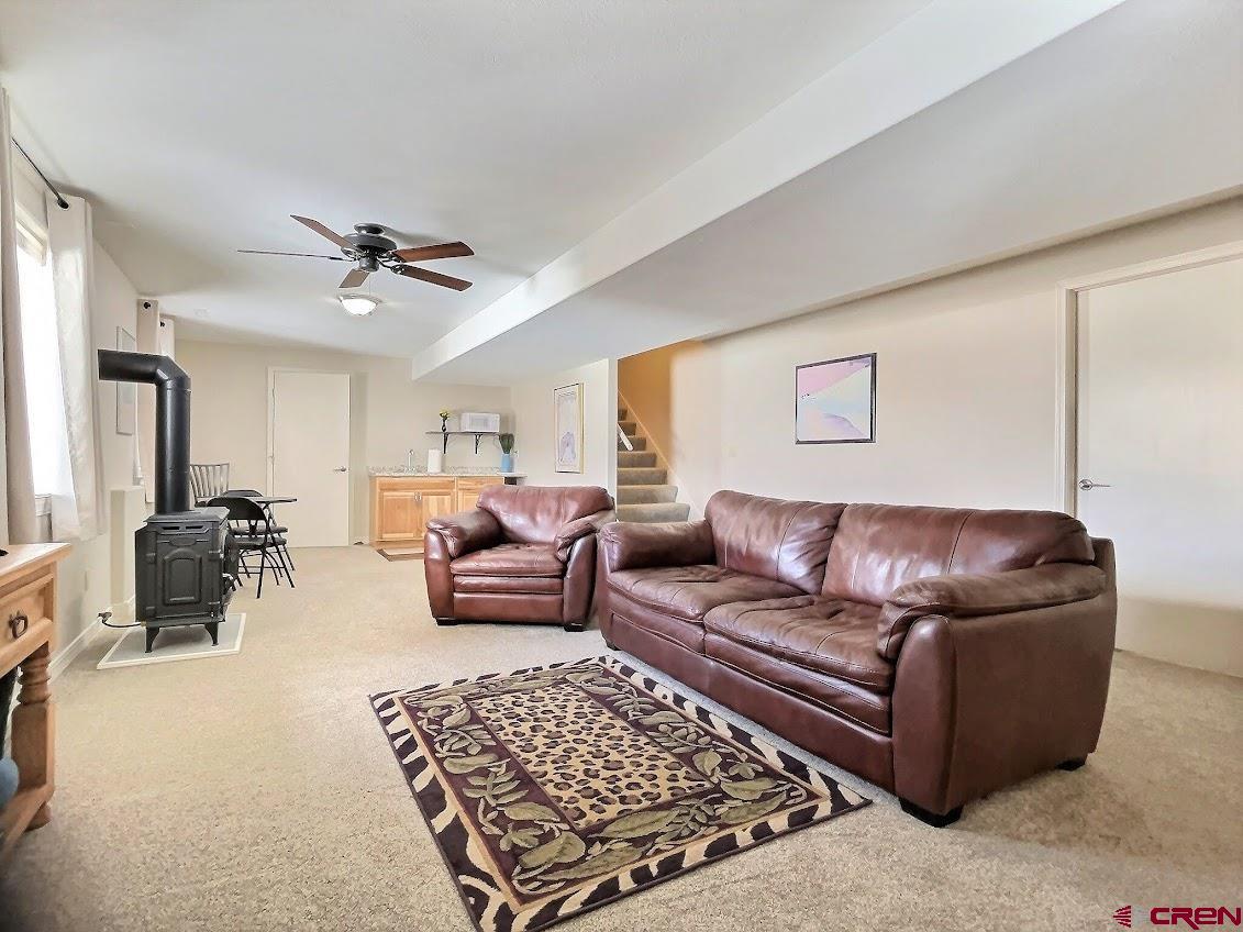 24835 Cactus Park Road Cedaredge, CO 81413 - Photo 15 of 35 a living room with furniture ceiling fan and a rug