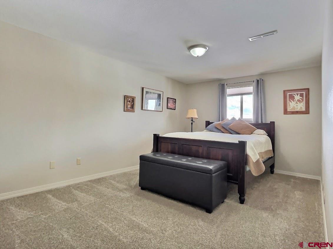 24835 Cactus Park Road Cedaredge, CO 81413 - Photo 18 of 35 a bedroom with a bed and window