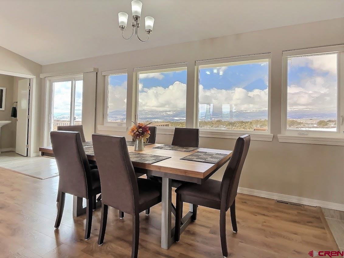24835 Cactus Park Road Cedaredge, CO 81413 - Photo 4 of 35 a view of a dining room with furniture large windows and wooden floor