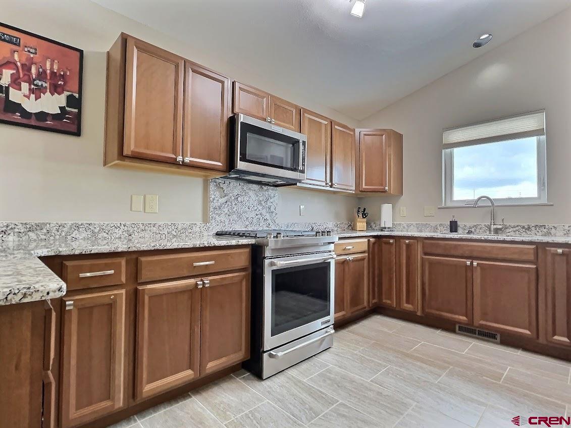 24835 Cactus Park Road Cedaredge, CO 81413 - Photo 7 of 35 a kitchen with stainless steel appliances granite countertop a stove sink and microwave